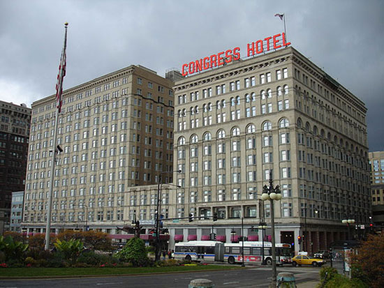 A large tall building with a clock on the side of a road