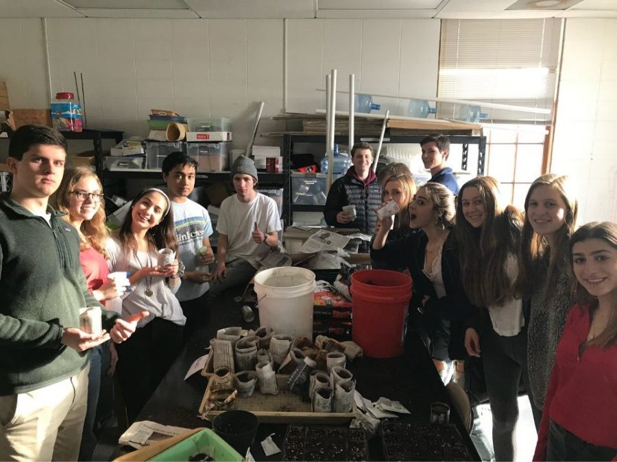 Environmental Club enjoys a brief break in the planting room. The club grows plants during the year and gives them away during Earth Week.