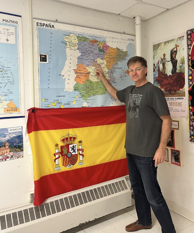 Profe next to a staple of his classroom, the map of Spain
