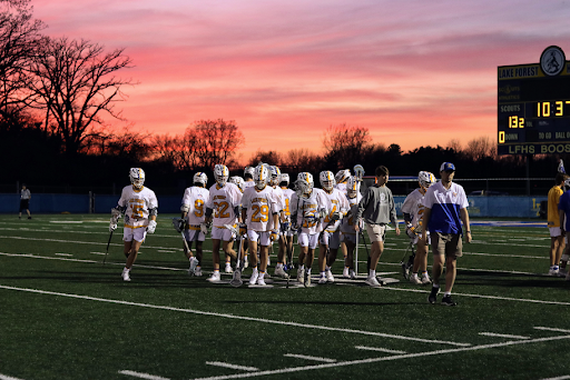 Boys lacrosse breaks from a huddle during a beautiful sunset at Lake Forest High Schools West Campus