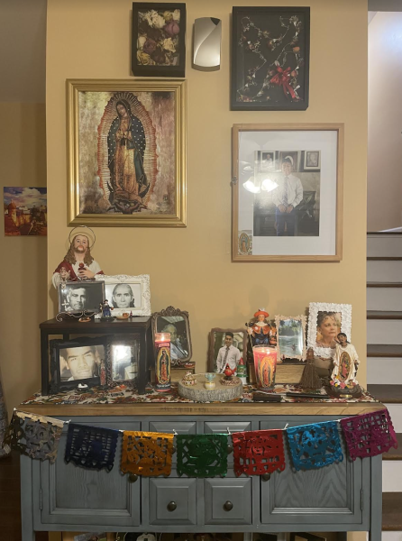 The altar that is put up every year at my dads house including pictures, candles, and papel picado. 