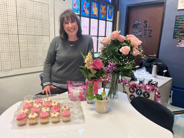 Mrs. Metz pictured with flowers, decorations, and baked goods celebrating her last day of treatment.