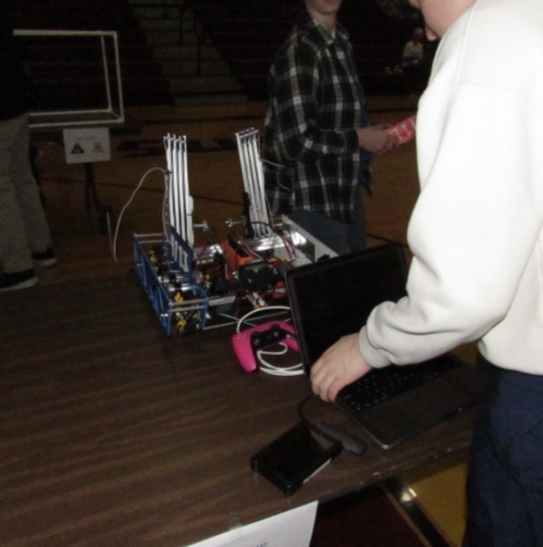 Minimum Cache, LFHS's team, waiting at an inspection table for an FTA to analyze and approve their robot, courtesy of Jason Kowalski