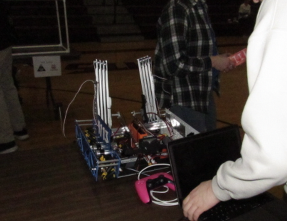 Minimum Cache, LFHS's team, waiting at an inspection table for an FTA to analyze and approve their robot, courtesy of Jason Kowalski