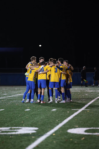 Boys' Varsity Soccer Team huddling.